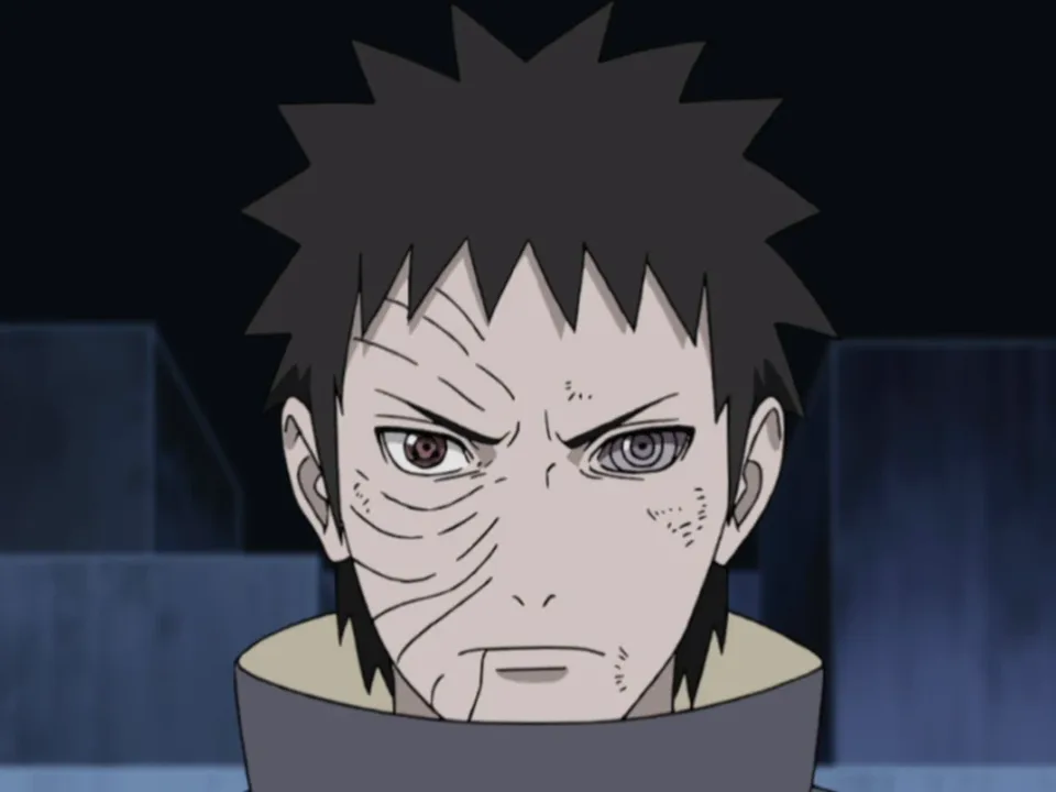 Portrait of a black-haired man with the right half of his face heavily scarred, wearing a swirled orange mask pushed aside
