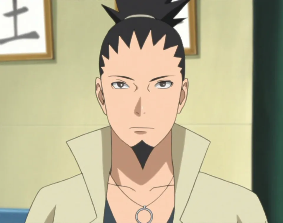 Portrait of a bored-looking boy with dark hair gathered into a spiky ponytail and narrow eyes, wearing a mesh shirt beneath a grey jacket.